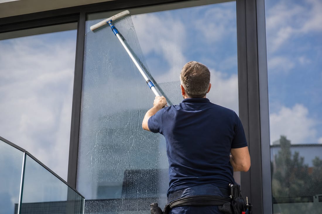 Beispiel: Fensterputzen mit Abzieher, Person von hinten